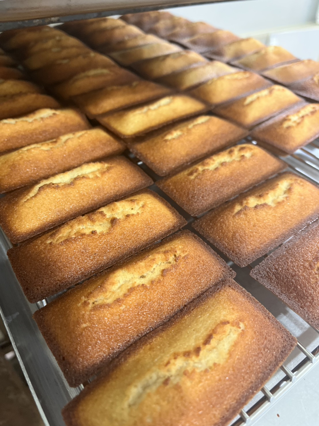 焦がしバターフィナンシェ - 丁寧に焼き上げたフィナンシェが並ぶ工房の風景